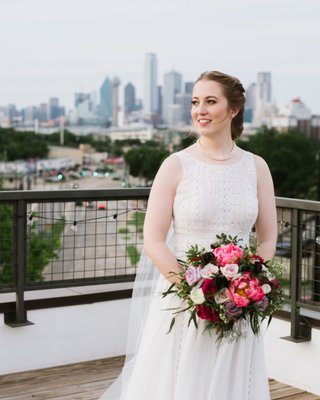 A Mockingbird Bridal bride photographed on a rooftop above the Dallas skyline